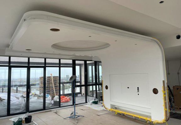 Penthouse met gebogen verlaagd plafond en glazen gevel tijdens afbouw in Amsterdam